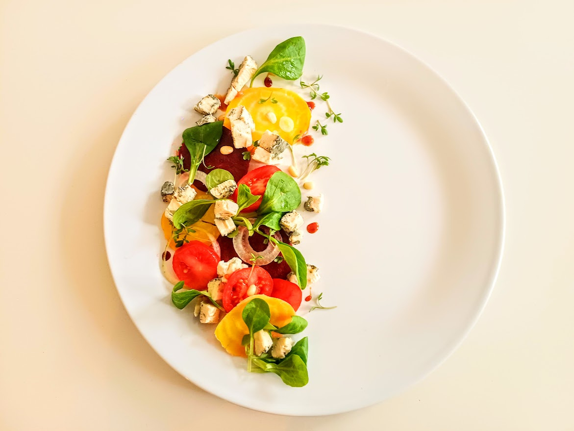 Colourful tomato salad with greens and pieces of Vegan-Lee blue cheese